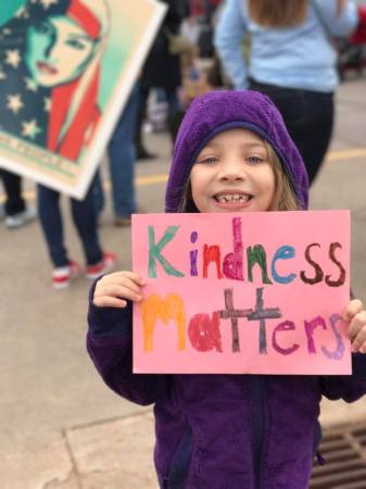 Young girl at Women's March (2017) holding a sign she made that reads "kindness matters"