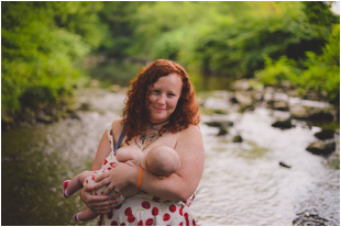 Shawna breastfeeding Zephyr near a creek in the woods